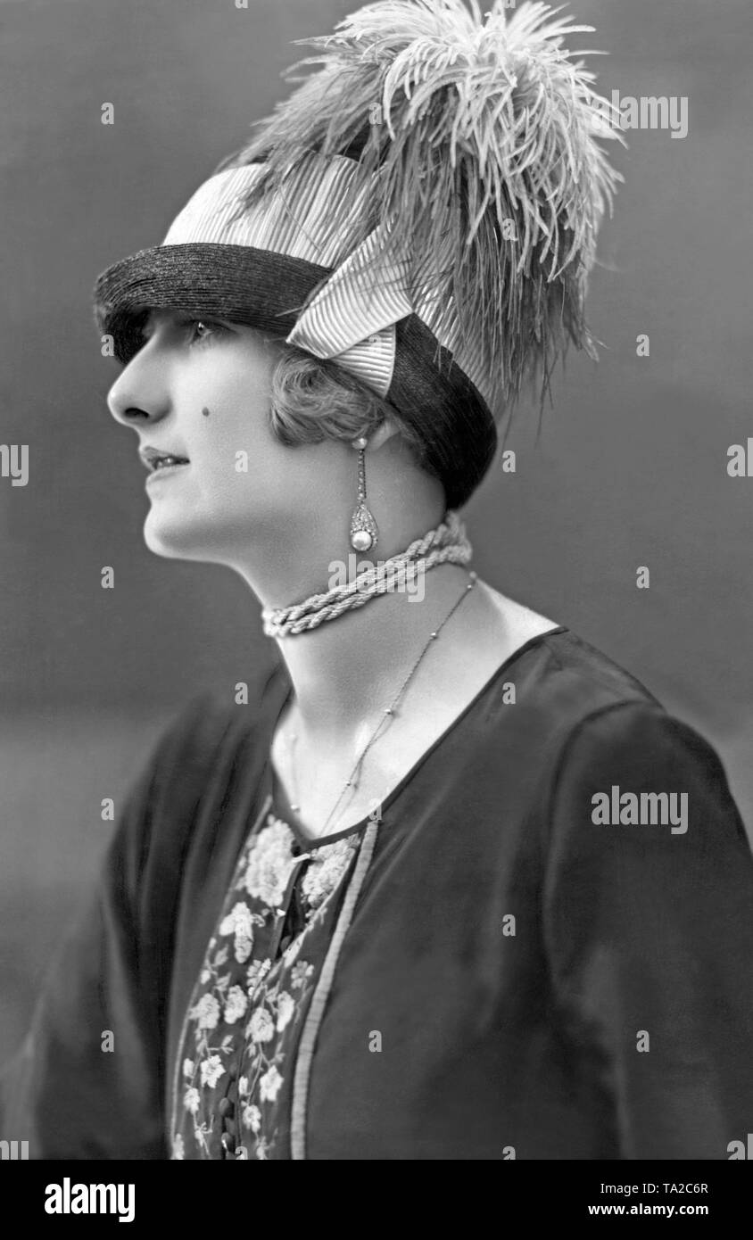 Modèle avec un chapeau de paille avec pédale violet foncé violet clair finition côtelée et glycerized violet plumes d'autruche. Banque D'Images