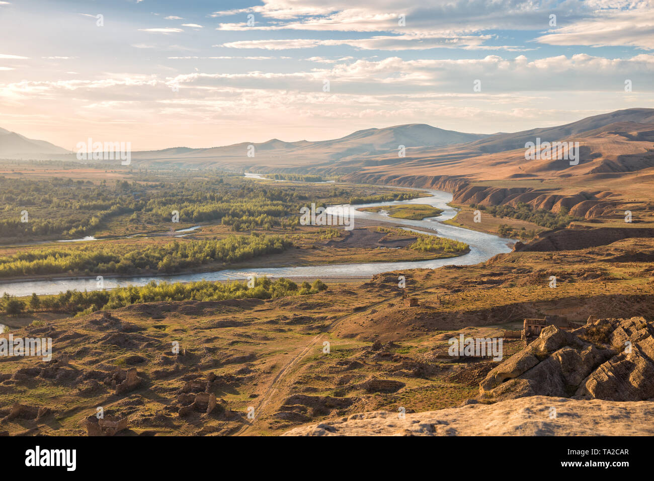 Beau paysage dans la soirée la lumière du soleil. Mtkvari River sur l'arrière-plan des montagnes du Caucase, sur les rives de la rivière ruines d'une cité médiévale Banque D'Images