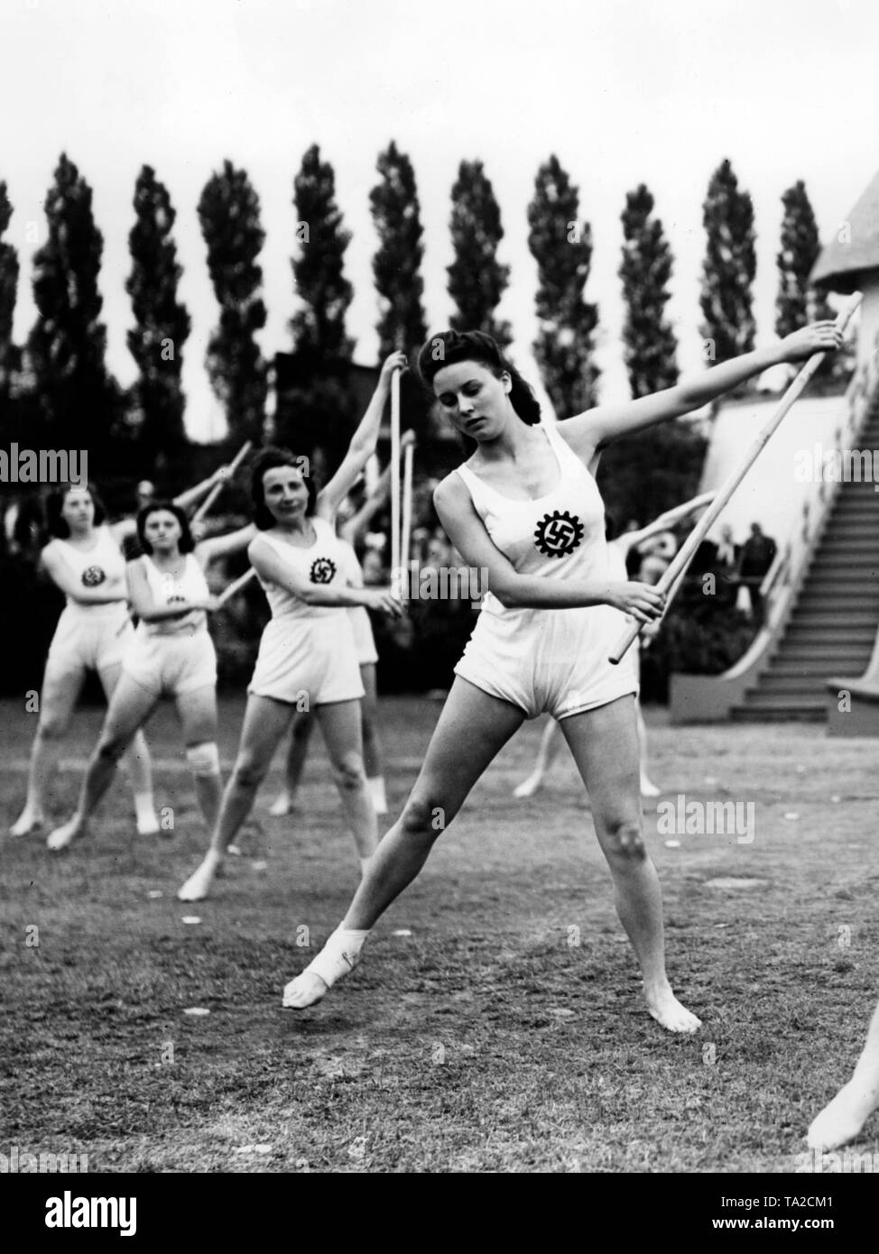 Les femmes font des exercices différents dans une compétition sportive de l'organisation Nazie "Kraft durch Freude" ('force par la joie") à la Funkturm Berlin. Ici, un baton de l'exercice. Banque D'Images