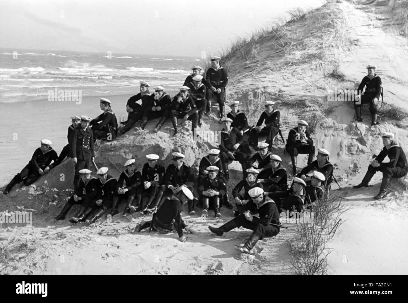 Recrues de la Kriegsmarine avec les instructeurs prennent une pause après l'exercice de perçage sur une dune sur une plage de Norderney. Banque D'Images
