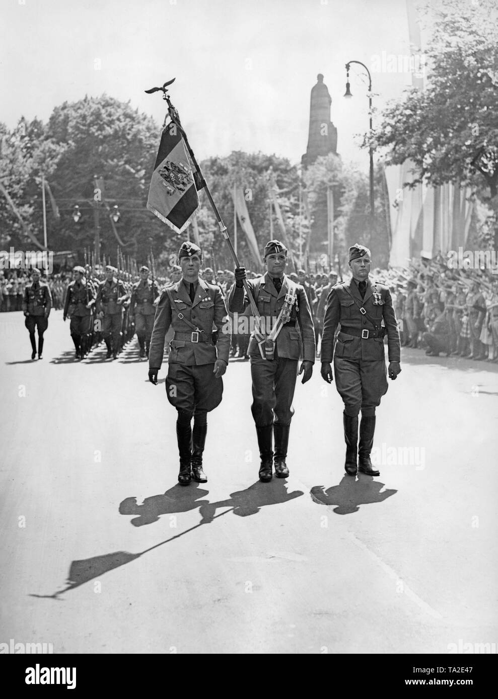 Photo de gardes couleur de la légion Condor durant la revue de la victoire de la Légion à Hambourg le 30 mai 1939. Les couleurs (Espagnol bandera) est porté par un caporal de l'épée de noeud. Sur la droite et sur la gauche, les officiers. Dans l'arrière-plan, le monument de Bismarck dans l'instruction Alter Elbpark à Millerntorplatz. Banque D'Images
