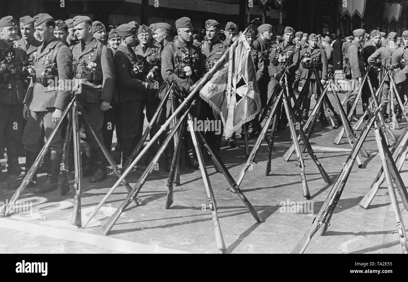 Les membres de la légion Condor (sous-officiers et les équipes) sont en attente pour le défilé à l'occasion de leur retour de la guerre civile espagnole sur Bismarkstrasse sur l'axe Est-Ouest à Berlin-Charlottenburg le 6 juin 1939. Ils ont mis en place leurs fusils et regimental standard. Banque D'Images