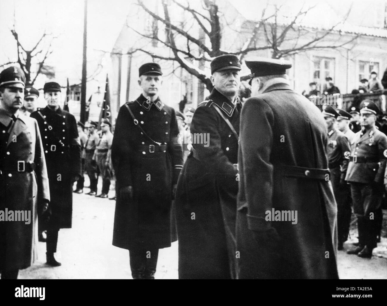 Ernst Neumann (au centre, à la recherche de l'appareil photo), le Memel leader Nazi, est accueilli à l'arrivée à la célébration marquant la reconstruction de la Memel mémorial à l'empereur Guillaume I, après l'annexion de la Memel salon par le Reich. Banque D'Images