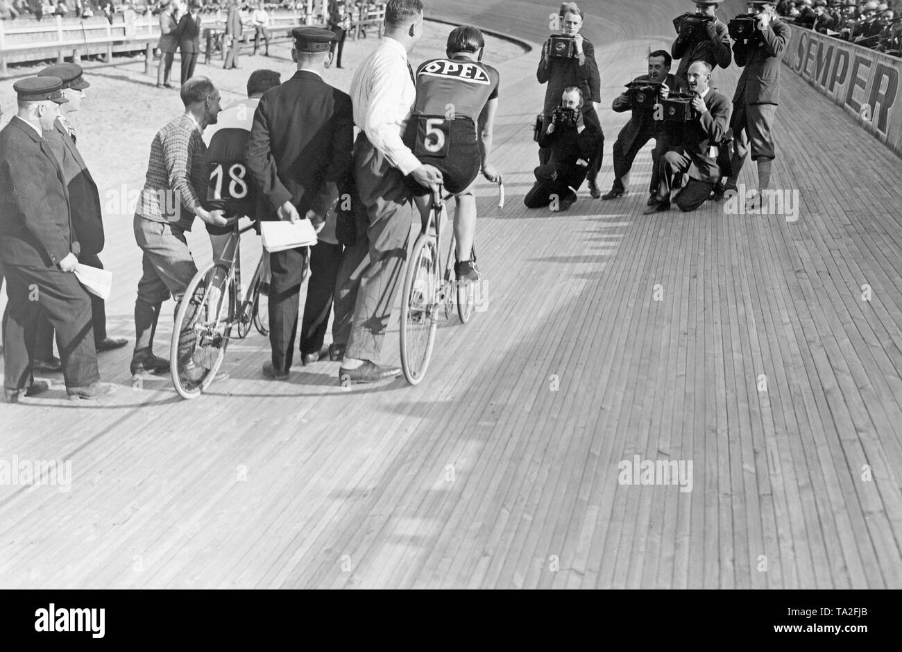 Deux voies cyclistes et leurs auxiliaires, préparez-vous pour le début d'une course à l'Ruett-Arena de Berlin. En face d'eux sont des photographes de prendre des photos. Banque D'Images