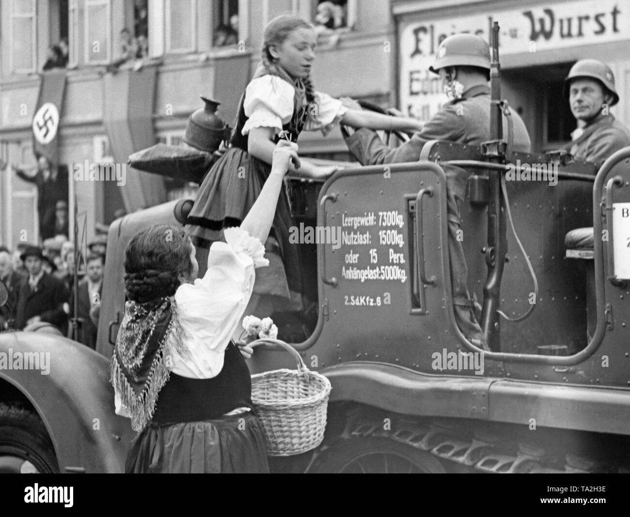 Une jeune fille monte dans un véhicule (Zugmaschine Sdkfz 6) de la Wehrmacht en Grottau (aujourd'hui Hradek nad Nisou) le 3 octobre 1938. Le véhicule appartient à l'une des troupes d'occupation de la ville et des Sudètes. Banque D'Images