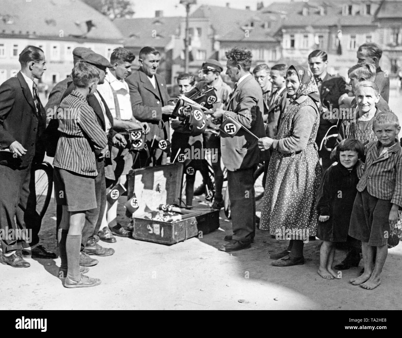 Drapeaux à croix gammée sont vendus sur la place du marché d'aujourd'hui (Schluckenau Sluknov) le 30 septembre 1938, avant l'arrivée des troupes allemandes pendant l'occupation des Sudètes. Banque D'Images