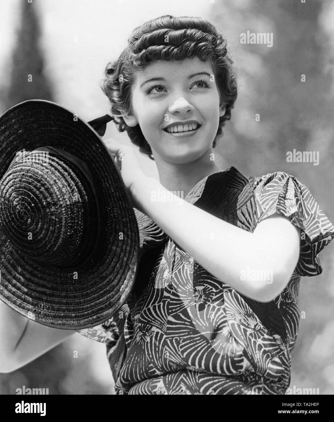Portrait de 17 ans, l'actrice Marsha Hunt. Elle porte une robe avec motif de feuille et un chapeau de paille. Banque D'Images