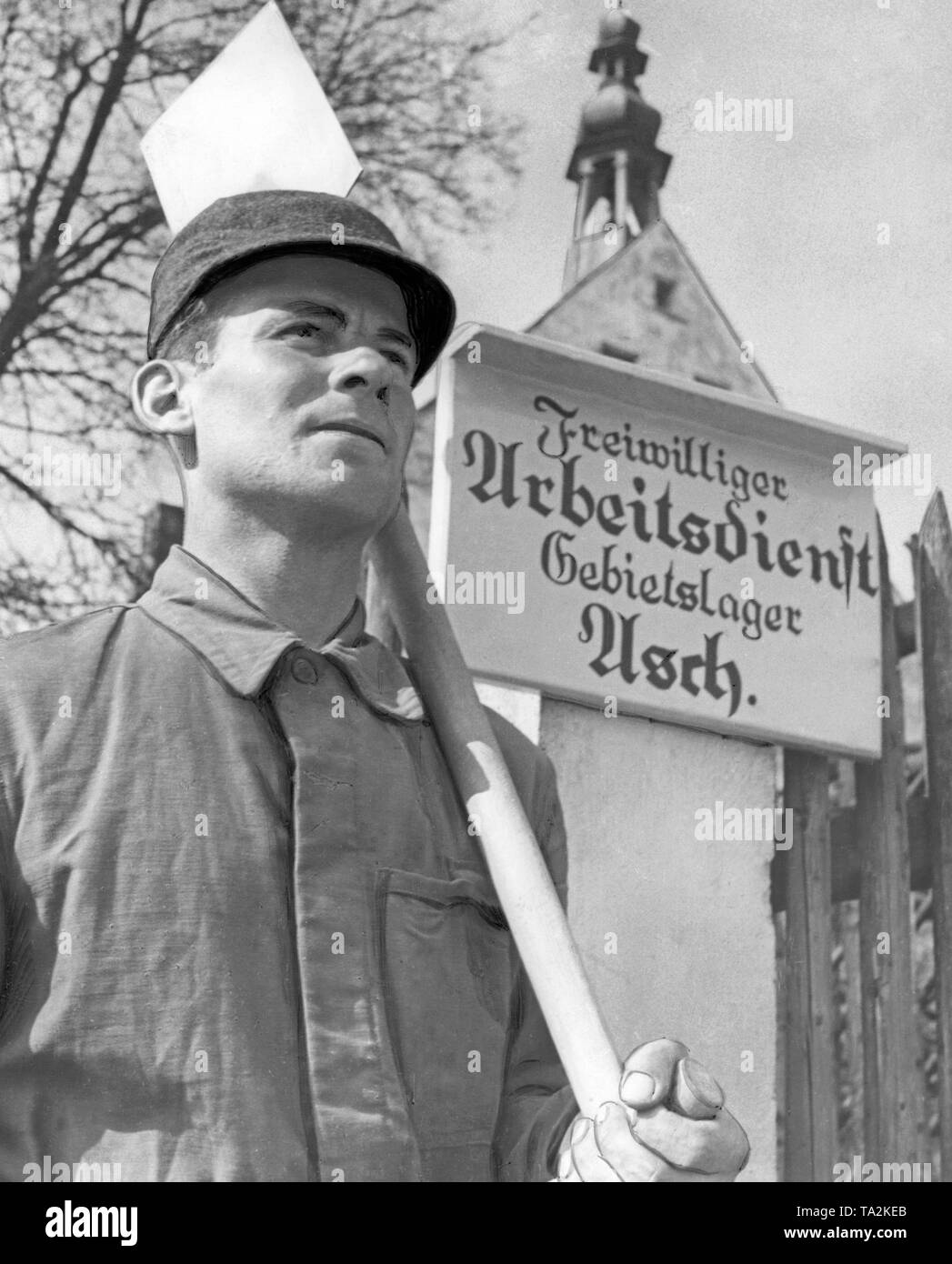 Membre du Service du travail en tant que, après l'occupation des Sudètes par les troupes allemandes en 1938. Derrière, un panneau avec l'inscription : 'Travail volontaire Service régional de Camp comme'. Banque D'Images