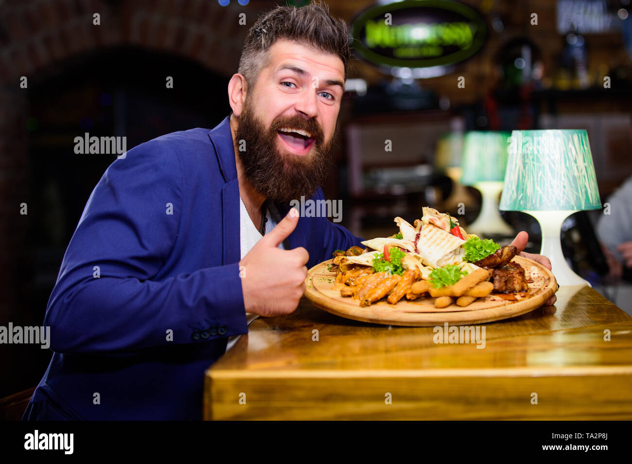Profitez de votre repas. Des calories. Vous pourrez vous détendre après une dure journée. La nourriture délicieuse. Woman costume formel s'asseoir au restaurant. L'homme a reçu de pommes de terre frites repas avec les bâtonnets de poisson viande. Il méritent de délicieux repas. Banque D'Images