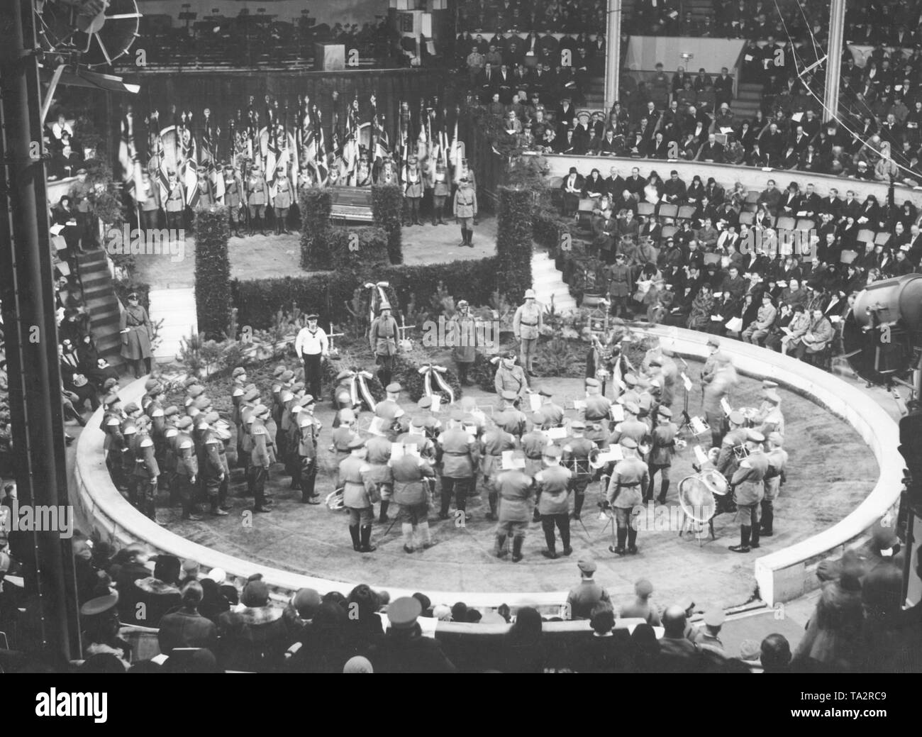 Le Stahlhelm célèbre le Heldengedenktag (Heroes Memorial Day) à Berlin avec trois tombes militaires imitées construit dans l'arène. Il y a un groupe de musique en face de la tombe. Banque D'Images