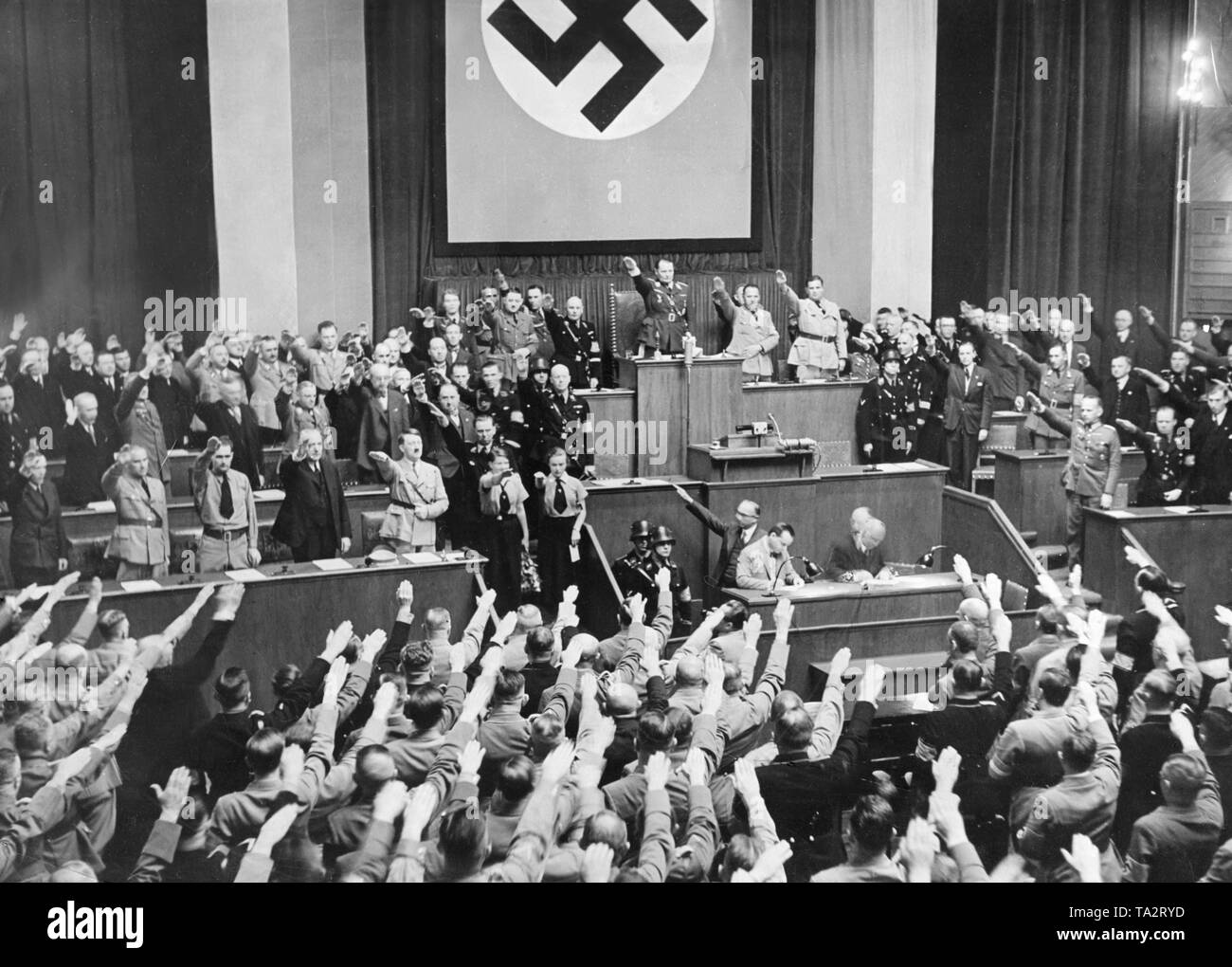 Après la perte de la SA dans le soi-disant Nuit des Longs Couteaux (Roehm-Putsch), Adolf Hitler a prononcé un discours devant le Reichstag à Berlin le Krolloper d'expliquer ses actions. Sommaire Au cours de la réunion et le salut nazi. Dans le siège du président du Reichstag, Hermann Goering (centre). À gauche de la première ligne de la banc du gouvernement Adolf Hitler, Konstantin von Neurath, Rudolf Hess, Wilhelm Frick. Juste à côté de Hitler, son chef Adjudant Julius Schaub, derrière Walther Funk. Banque D'Images