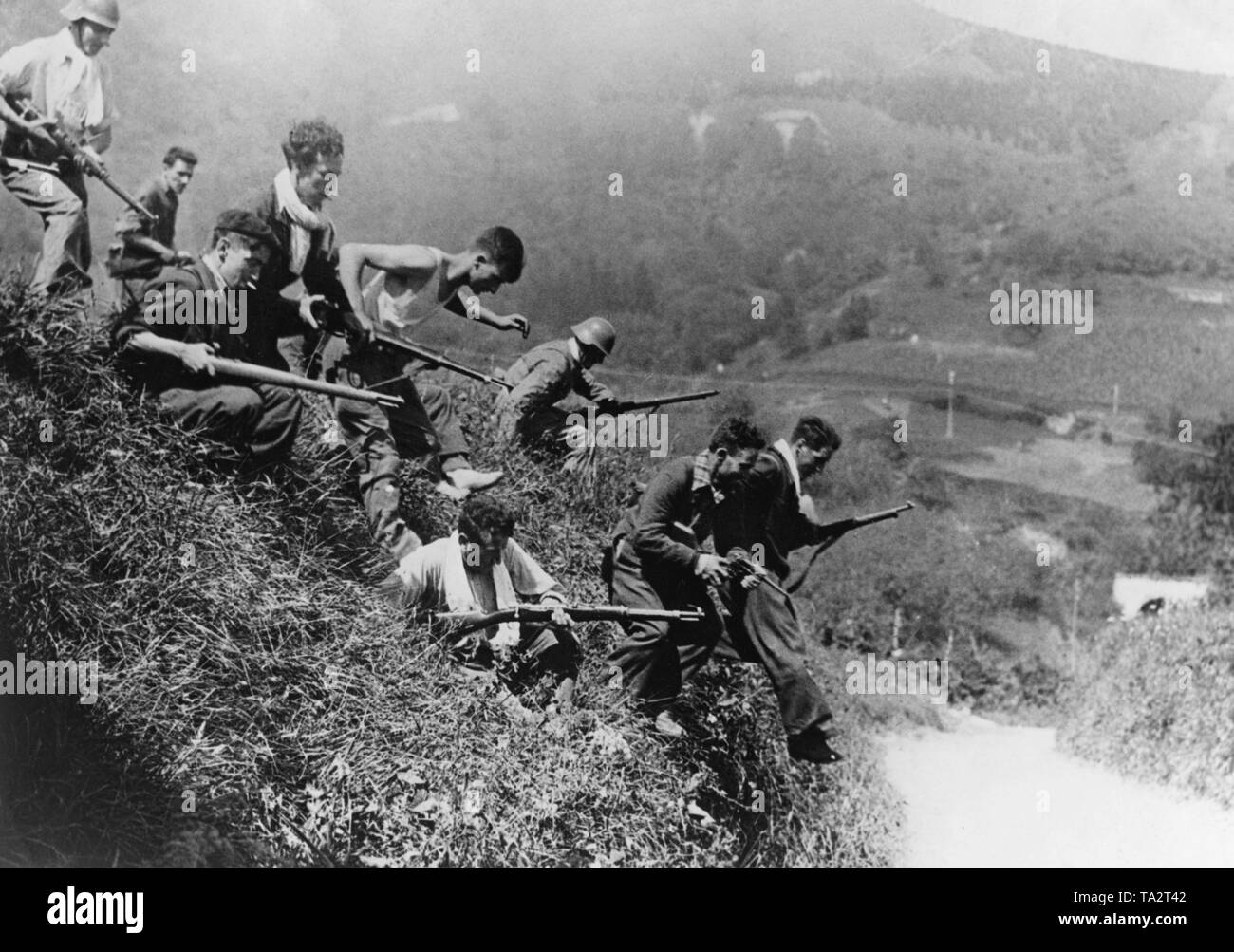 Un groupe de combattants loyaux au gouvernement une rue de tempête au pays Basque entre San Sebastian et de la ville frontalière d'Irun (France). Les miliciens sont habillés civils armés de fusils Gewehr 98. Deux d'entre eux porter des casques d'acier espagnol. Banque D'Images