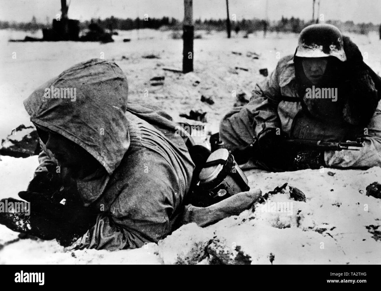 Deux Waffen-SS hommes se couvrir de missiles ennemis. Vraisemblablement, ils sont situés au sud du lac Ladoga dans la partie nord du front de l'Est. Photo de l'entreprise de propagande (PK) : correspondant de guerre Raudies. Banque D'Images