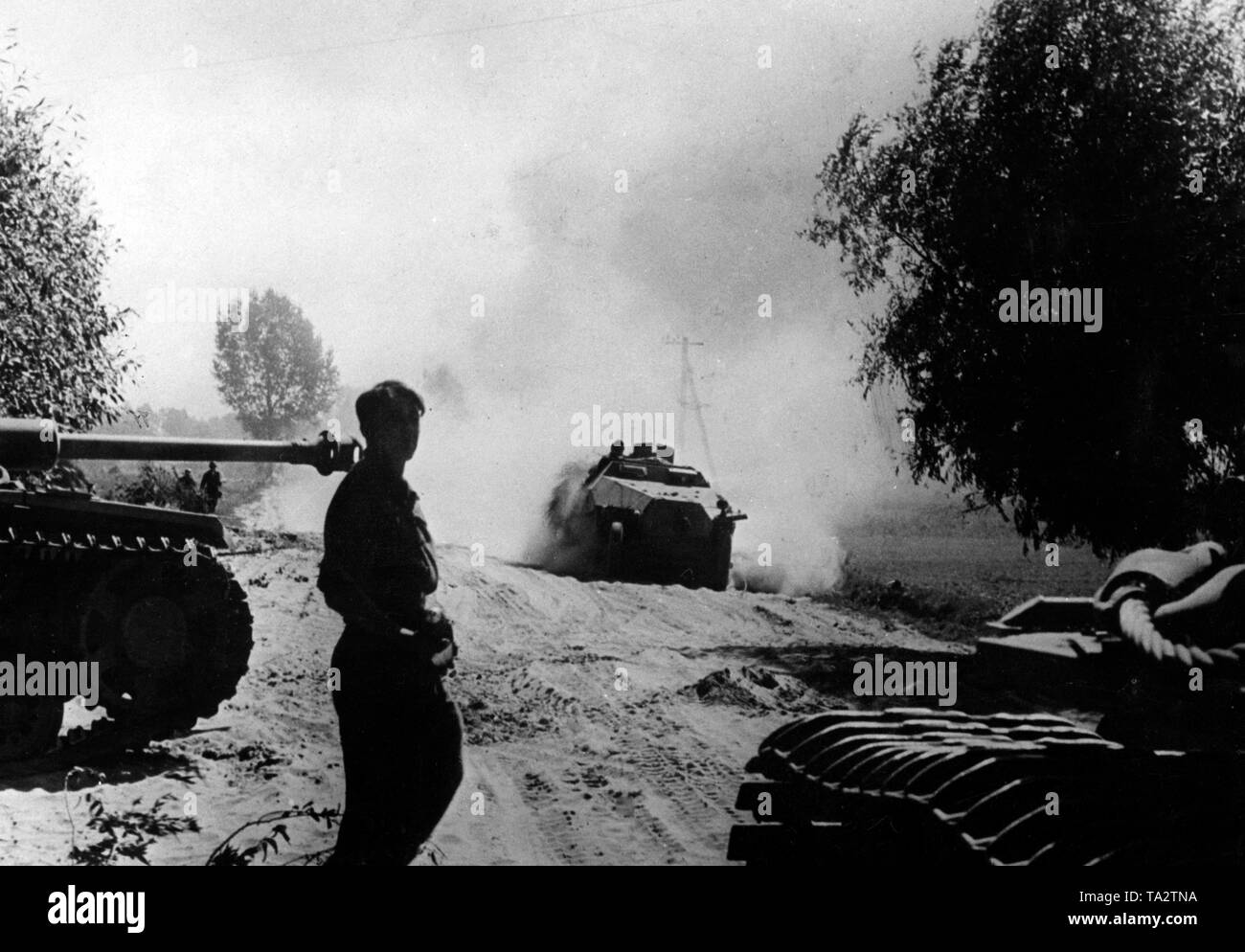 Un soldat debout à côté de blindés est en attente de l'arrivée d'un véhicule de transport de troupes (SD.KFZ. 250 o. 251). C'était censée fournir les munitions nécessaires pour les réservoirs de continuer la lutte sur le front de l'Est (sans doute l'Est de la Pologne ou de la Biélorussie). Photo de l'entreprise de propagande (PK) : correspondant de guerre Groenert. Banque D'Images