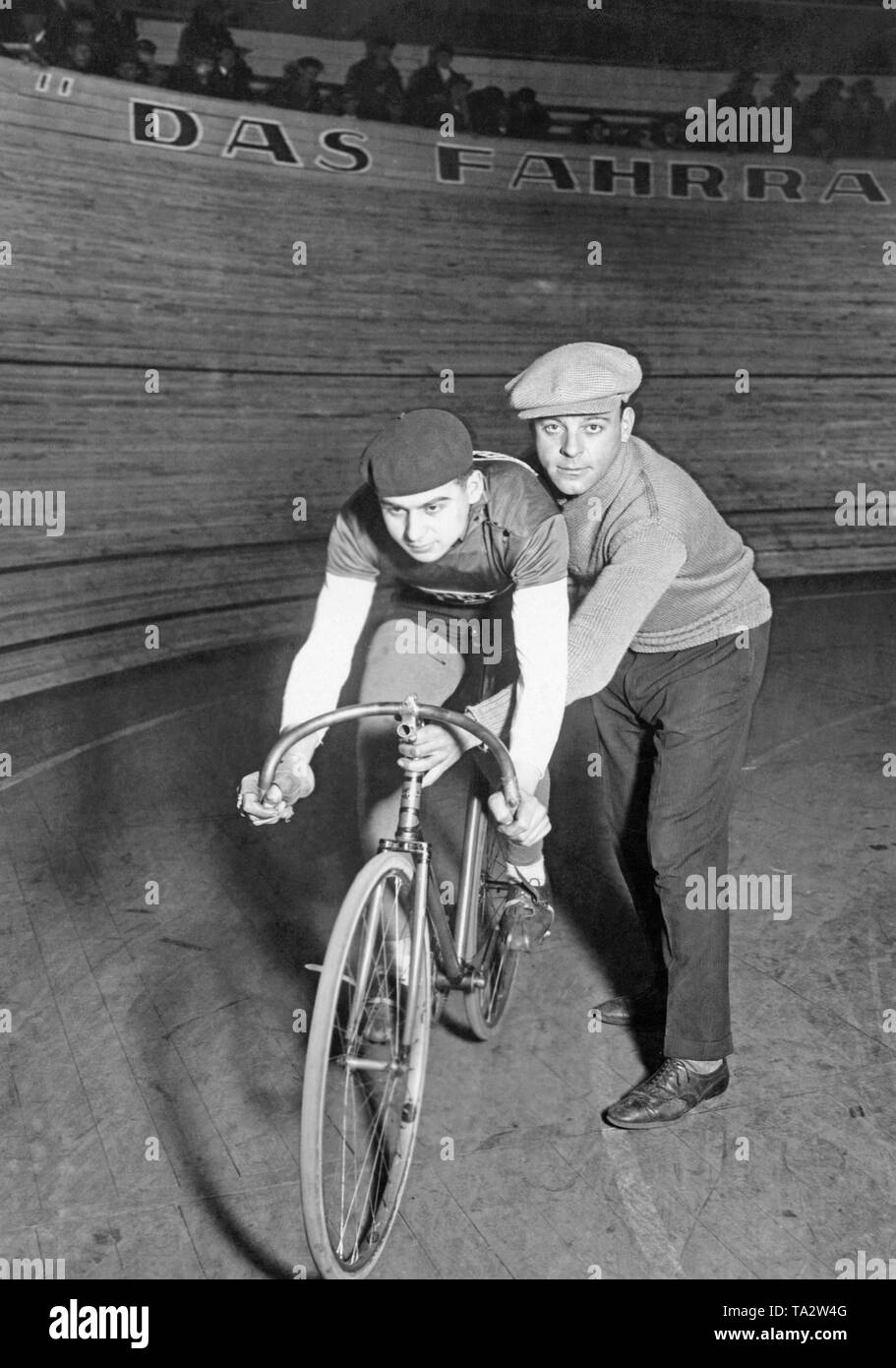 Une piste cycliste et son adjoint qui prend en charge lui, posant pour une photo en face de la piste cyclable dans le Berlin Sportpalast avant le début de la période de six jours de course. Banque D'Images