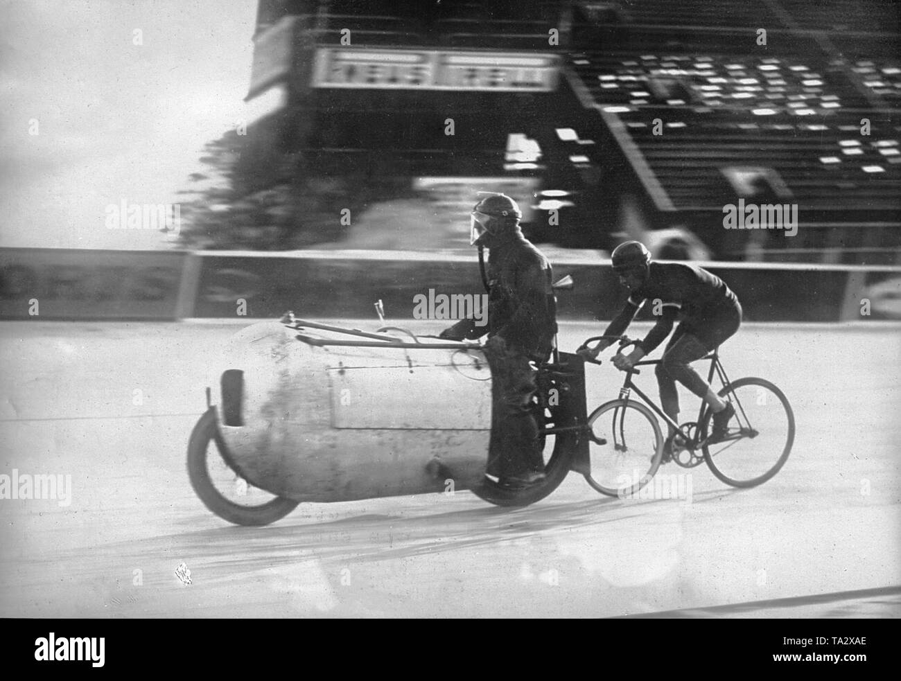 Au cours d'une piste à l'Autodrome de Montlhery en France, le défaut de la conduite en face de la piste cyclistes utilise un masque qui est connecté à un microphone en forme d'entonnoir sur le dos. Avec l'aide de ce microphone, les cyclistes et les pacers peuvent communiquer pendant la course. Le Pacer conduit une moto avec un carénage aérodynamique. Banque D'Images