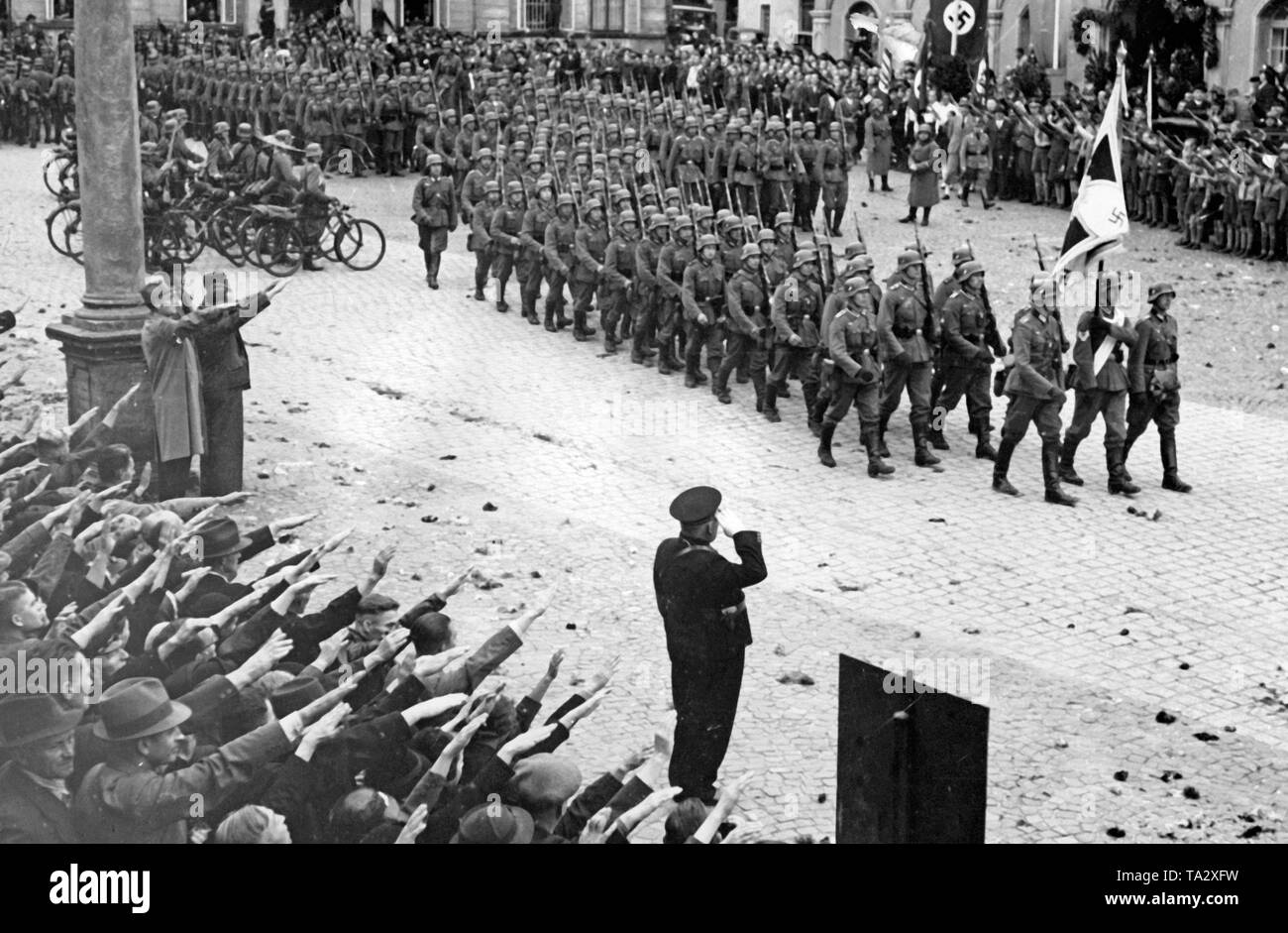 Les troupes allemandes en mars (Grottau aujourd'Hradek nad Nisou) le 3 octobre 1938. Les gens saluent les soldats avec le salut nazi. Banque D'Images