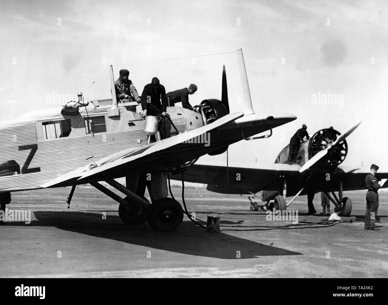 Les élèves-pilotes et le personnel au sol de la Luftwaffe pendant le ravitaillement d'un Junkers W 34, ce type d'avion a été fréquemment utilisé par la Luftwaffe en tant que moteur de l'école. Banque D'Images
