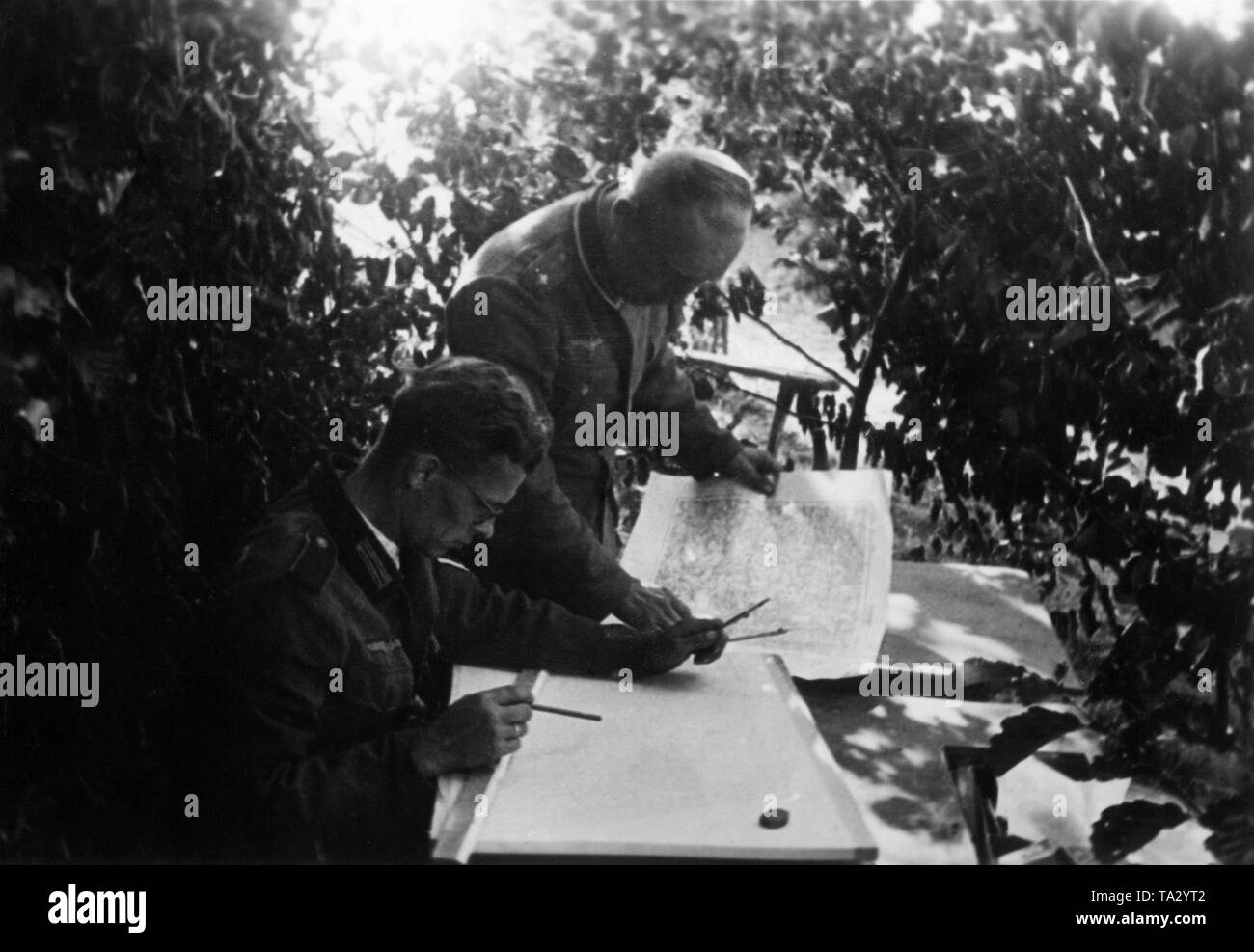 Tireur d'un Korpskartenstelle (Corps) Unité de carte de la Wehrmacht attire de nouveaux résultats du scoutisme dans les cartes existantes. À Borowka. Un lieutenant est assis en face, un premier lieutenant derrière lui. Photo : reporter de guerre Utecht. Banque D'Images