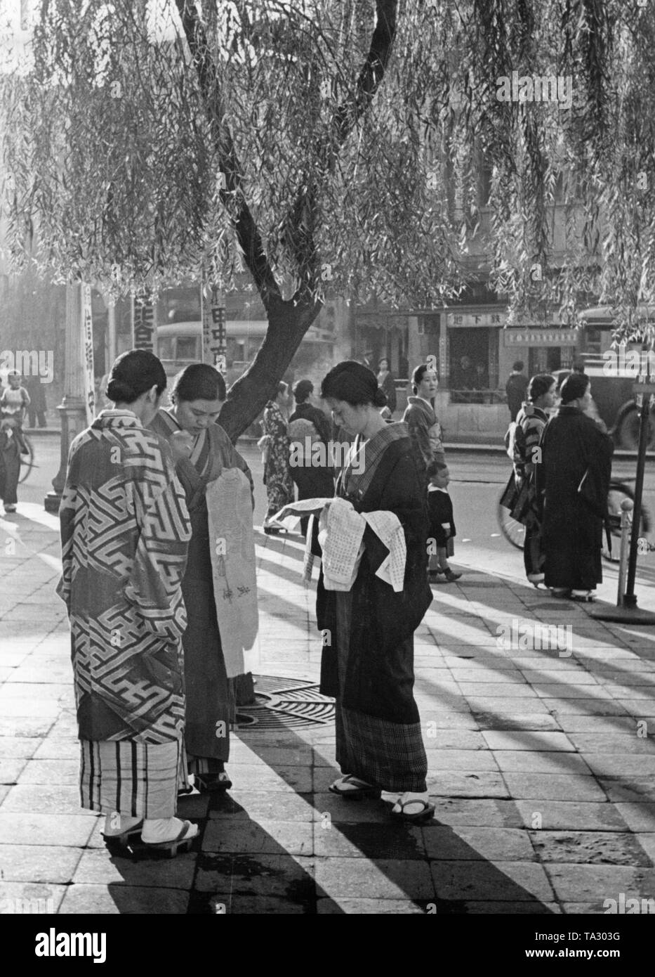 Épouses de soldats combattant sur l'avant de broder des écharpes de Tokyo, Ginza d'affaires et de divertissement. Les passants, qui souhaitent exprimer leur sympathie, prendre les vêtements et faire quelques points de suture eux-mêmes. Banque D'Images