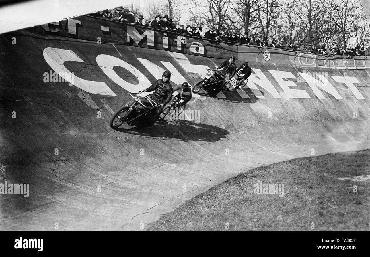 Les cyclistes sur piste deux à un moteur de course dans le quartier. Les Pacers en voiture en face d'eux. Banque D'Images
