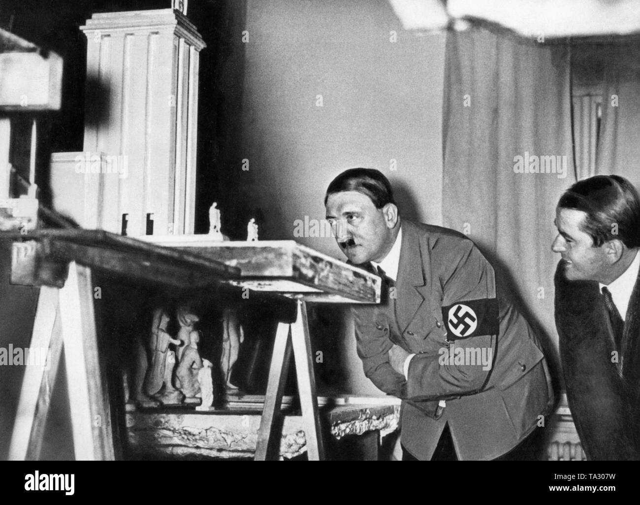 Adolf Hitler se penche sur le modèle du pavillon allemand pour l'Exposition Universelle de Paris en 1937. À côté de lui se trouve l'architecte Albert Speer. Banque D'Images