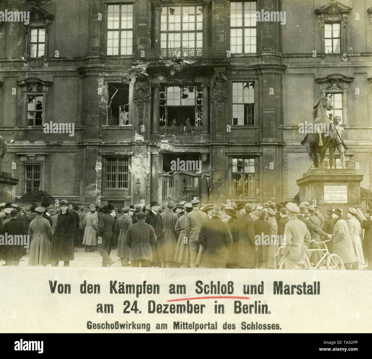 Les spectateurs en face de la destruction du portail central de la Ville Impériale Palace à Berlin Mitte. Sur la droite est un cheval statue, sur la base de ce qui est le cas d'une plaque avec l'inscription "socialisme & Travail". Le dommage est causé par les combats entre les forces gouvernementales et les membres de la Volksmarinedivision. Banque D'Images