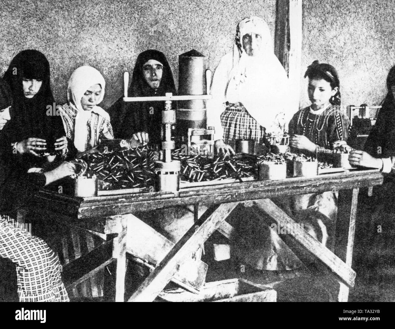 Photo de femmes turques et les filles la production de munitions. Ils remplissent les douilles de cartouche avec la poudre à fusil. Banque D'Images