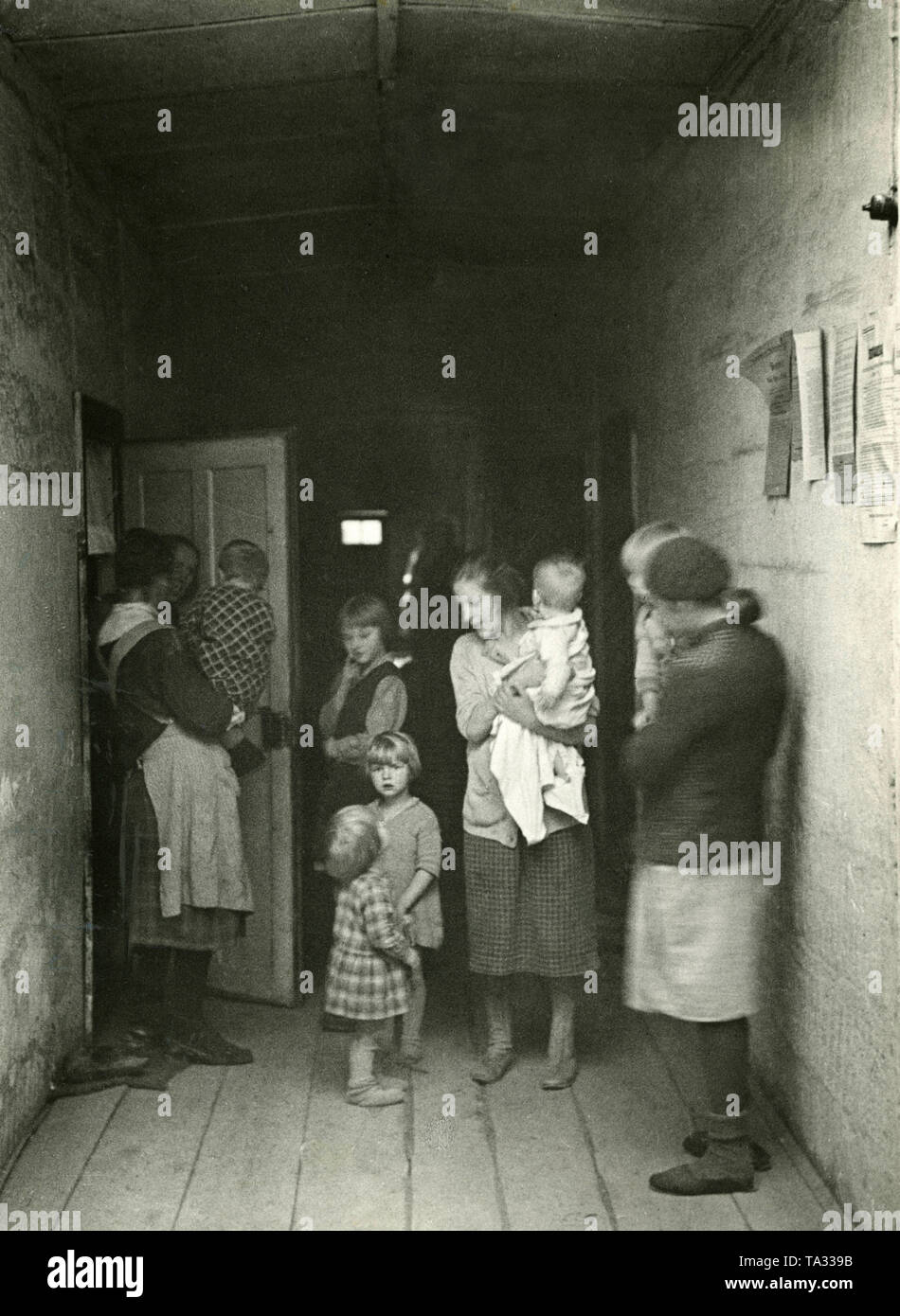 De nombreux chômeurs vivaient avec leurs familles dans des maisons collectives et modeste cave chambres avec installations sanitaires insuffisantes, qui ont été partagés par jusqu'à 25 parties. Au cours de la Grande Dépression, est certains cas ils étaient affamés pendant des jours, semaines, mois et années. De nouveaux vêtements n'est pas abordable et souvent il n'y avait rien d'autre que du pain rassis. La photo montre plusieurs femmes avec enfants. Banque D'Images