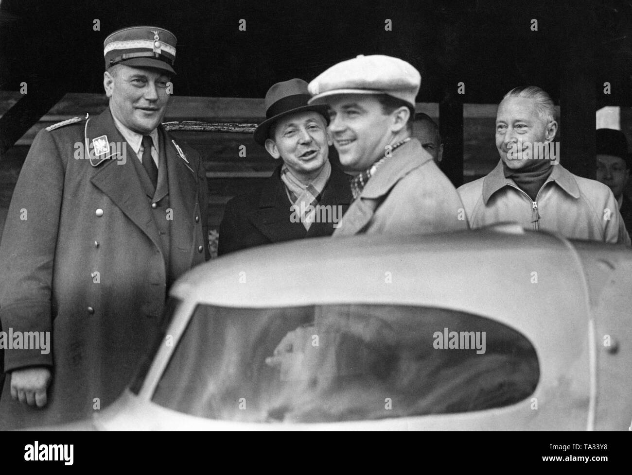 De gauche à droite : Obergruppenfuehrer et capitaine-adjudant de Hitler, Wilhelm Bruckner (en uniforme), le pilote de course Rudolf Caracciola (béret) et du Prince Guillaume de Prusse (à droite sans couvre-chef). La photo montre les trois peu de temps avant une nouvelle tentative de record de Caracciola avec sa Mercedes sur le Berliner Automobil-Verkehrs- und uebungsstrasse (AVUS). Banque D'Images