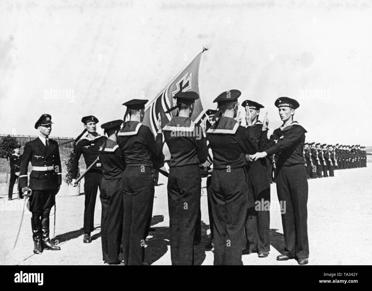 Recrues de la Kriegsmarine sont assermentés sur Adolf Hitler. Sur la gauche est un officier avec un sabre tiré. Le drapeau est le Reichskriegsfahne (drapeau de guerre). Banque D'Images