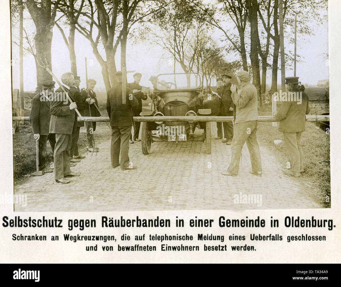 La population des hommes armés d'une municipalité à Oldenburg. Ils se tiennent à une barrière qui est fermé pour empêcher des raids et est gardé par les membres de la communauté. Derrière la barrière, un conducteur est contrôlé. Il s'agit d'une barrière à l'automobile de la marque Sperber 1911 (Norddeutsche Automobilwerke). Banque D'Images