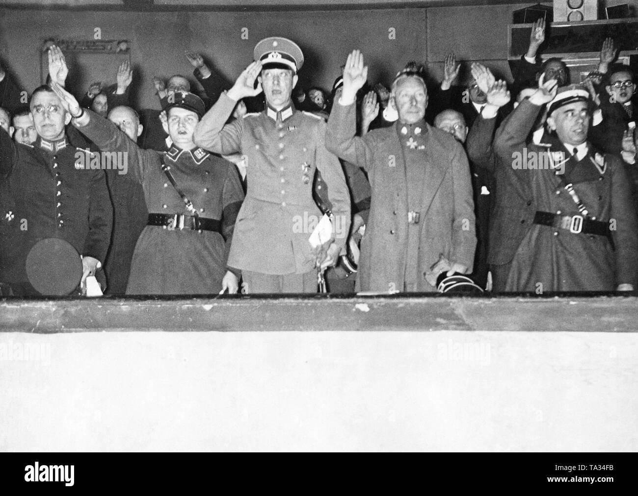 Le Prince Guillaume de Prusse (2e à partir de la droite) et Leader Sports Reich Hans von Tschammer et Osten (à droite) lors de l'ouverture de la piscine de Berlin Festival du sport dans la région de Berlin-Schoeneberg Sportpalast. Le Prince et les autres invités d'honneur de l'armée impériale, la police ainsi que les politiciens ont soulevé leurs mains dans le salut nazi. Banque D'Images