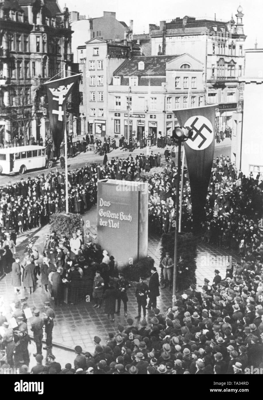 Sur le Kohlemarkt , organismes de bien-être social de la NSDAP inaugurer le Mémorial 'Das Goldene Buch der not' ('Le Livre d'or de la détresse"). C'était l'appel aux citoyens de Gdansk à devenir l'organisme de bienfaisance pour le national-socialisme et devrait être un rappel de la crise économique et les difficultés financières. Parmi les personnes présentes sont également membres du Sénat, le NSDAP, les SA et les SS. À côté du drapeau à croix gammée, le drapeau est hissé de Gdansk sur le mât. Banque D'Images