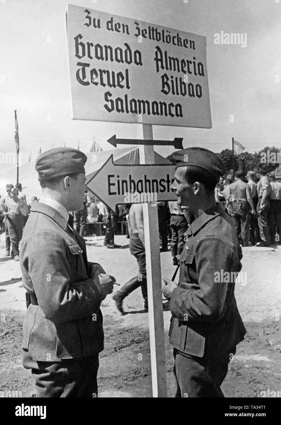 Photo de deux soldats de la légion Condor dans le camp de la Légion à Doeberitz, près de Berlin, le 5 juin 1939, un jour avant le grand défilé à l'occasion du retour des troupes de l'Espagne. Derrière eux, il y a un panneau. Les tentes des soldats de la légion Condor sont nommés d'après les batailles de la guerre civile espagnole. Il y a d'autres soldats dans l'arrière-plan. Les officiers étaient logés au village olympique de Elstal. Banque D'Images