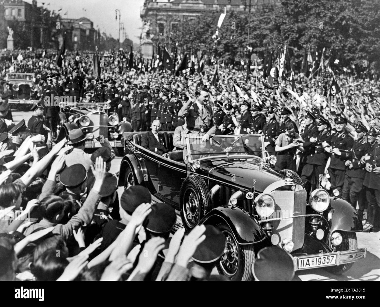 Adolf Hitler dans la voiture sur le chemin à un rallye sur la 'journée de travail national' dans le Lustgarten de Berlin. Franz von Papen est assis à l'arrière de la voiture. Banque D'Images