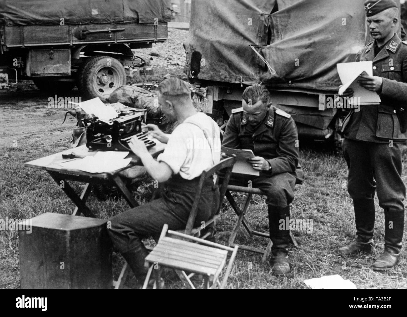 Les membres d'une unité de communication de la Wehrmacht sur le front de l'Est. Un soldat typs de commandes sur une machine à écrire. Deux officiers de la Luftwaffe dans le grade de lieutenant fournissent de l'information. Photo : Luden reporter de guerre. Banque D'Images