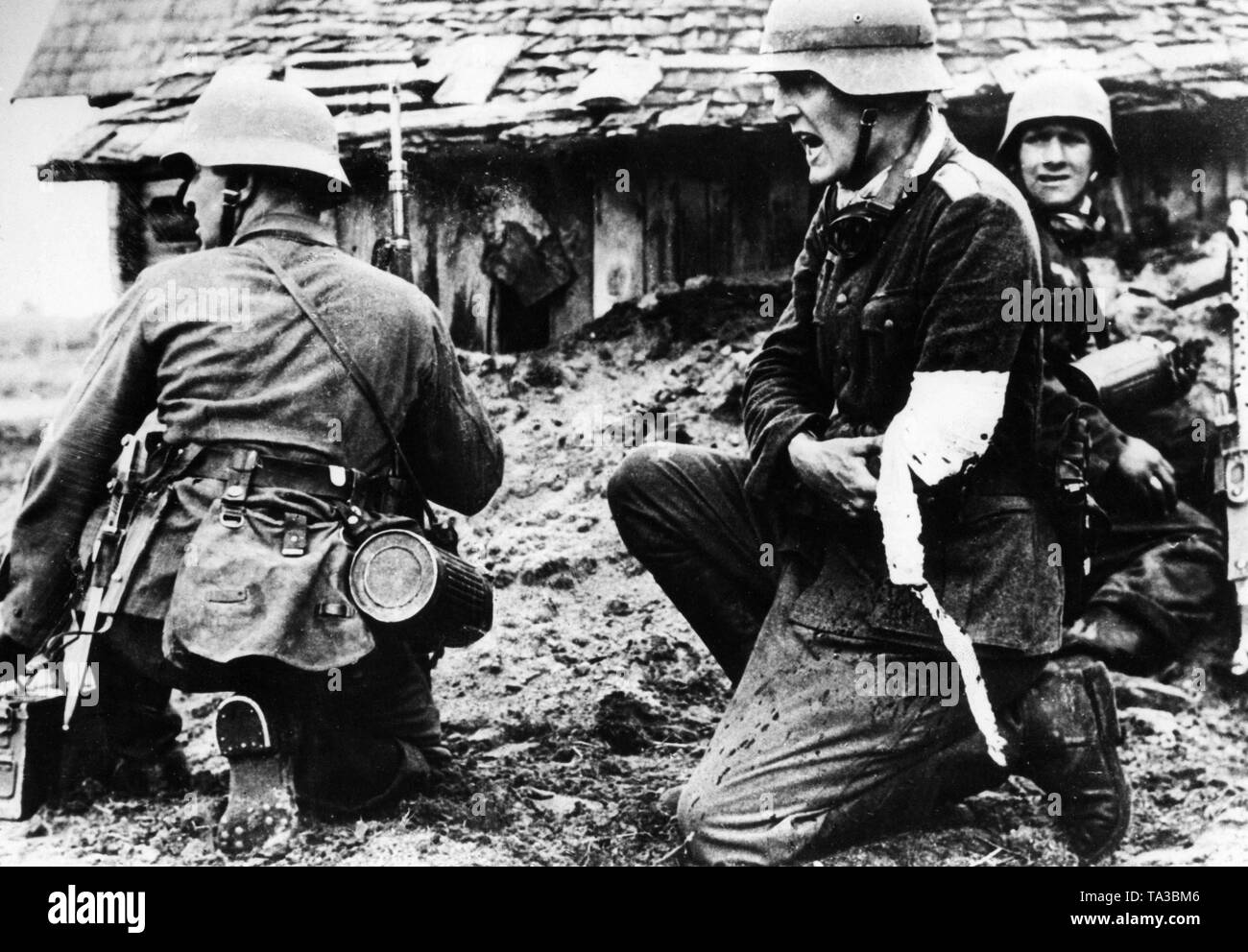 Un commandant de compagnie blessé ses soldats donne de nouvelles commandes. Sur la droite une machine gunner avec Mg-34th Banque D'Images