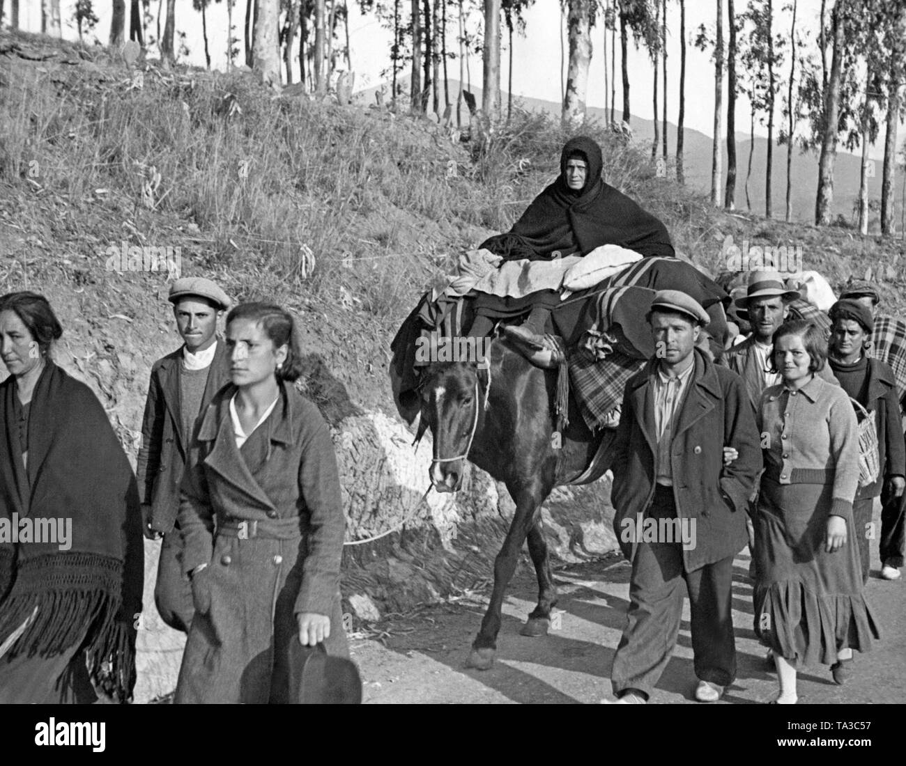 Des réfugiés espagnols retour à Malaga après sa conquête par les troupes nationales espagnoles le 8 février,1937. Une vieille femme est assise sur un cheval de bât. Banque D'Images