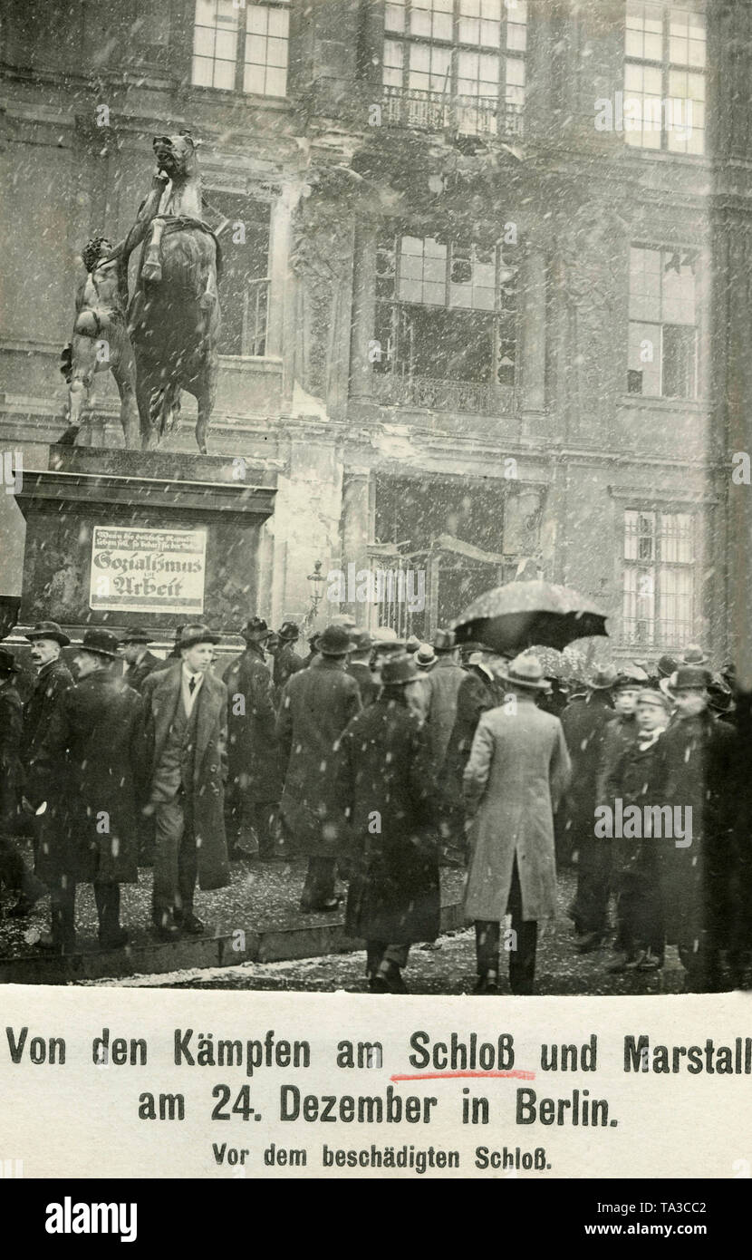 Les spectateurs en face de la destruction du portail central de la Ville Impériale Palace à Berlin Mitte. Sur la gauche est un cheval statue, sur la base de ce qui est le cas d'une plaque avec l'inscription "socialisme & Travail". Le dommage est causé par les combats entre les forces gouvernementales et les membres de la Volksmarinedivision. Banque D'Images
