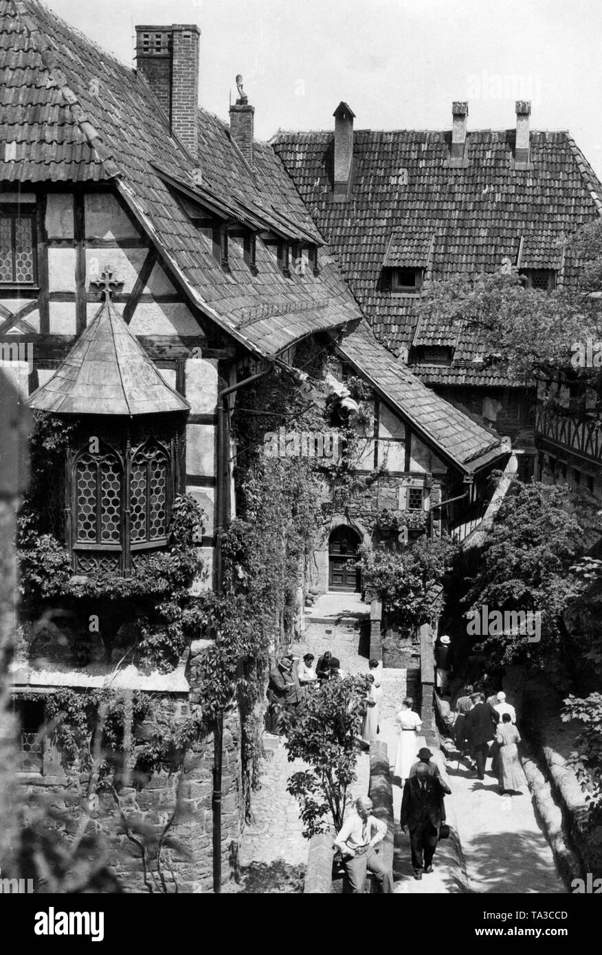 Vue sur la cour intérieure de la Wartburg sur la ville d'Eisenach, la Prusse. Ici sont présentés les envahis par les bâtiments à colombages de la cité médiévale du château de la colline. Les visiteurs marchent au premier plan. Banque D'Images