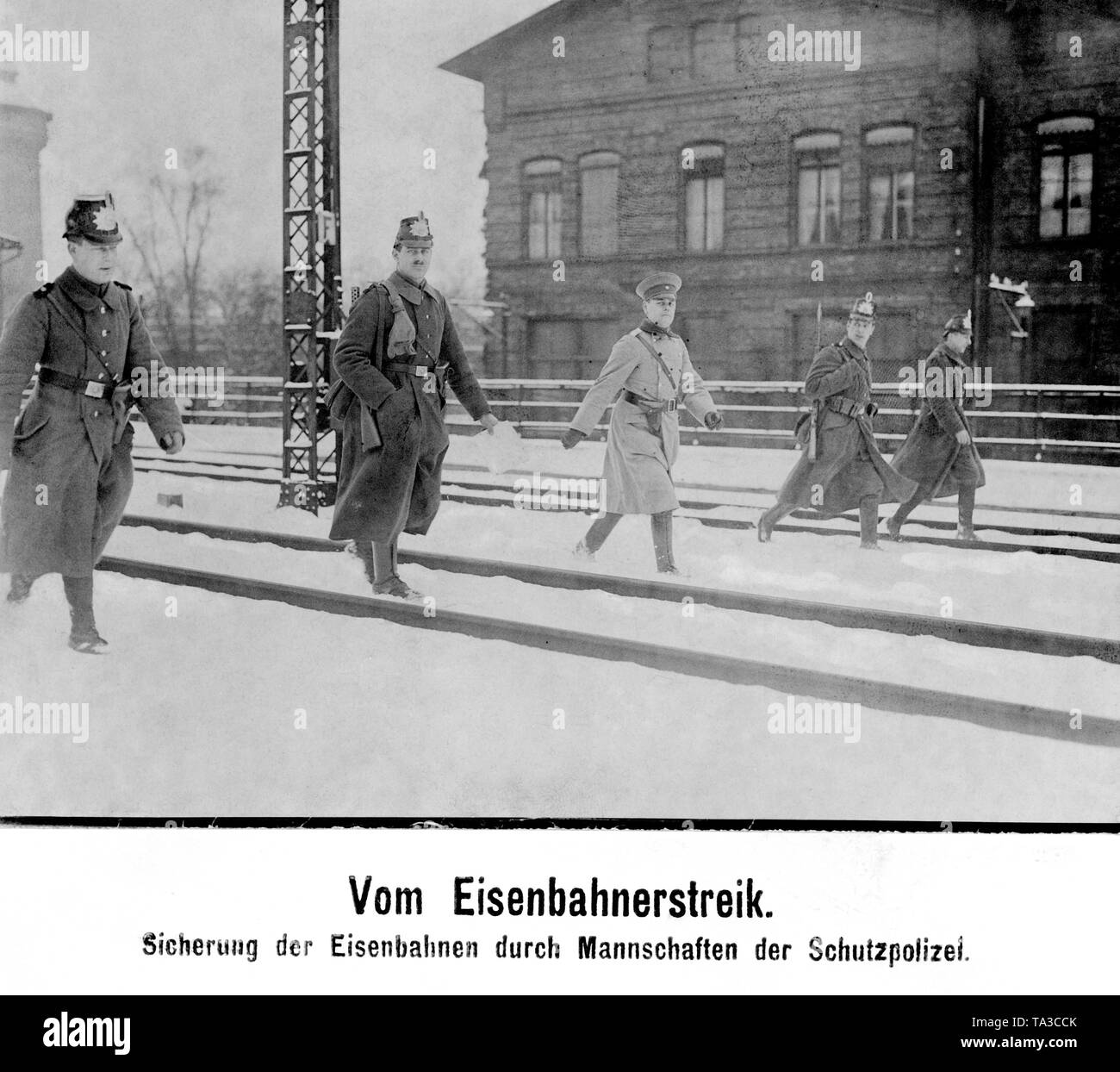 Un agent de la Schutzpolizei monte la garde lors d'une ligne de chemin de fer avec quatre policiers armés contre les attaques par les grévistes et les communistes à la périphérie de Berlin. Banque D'Images