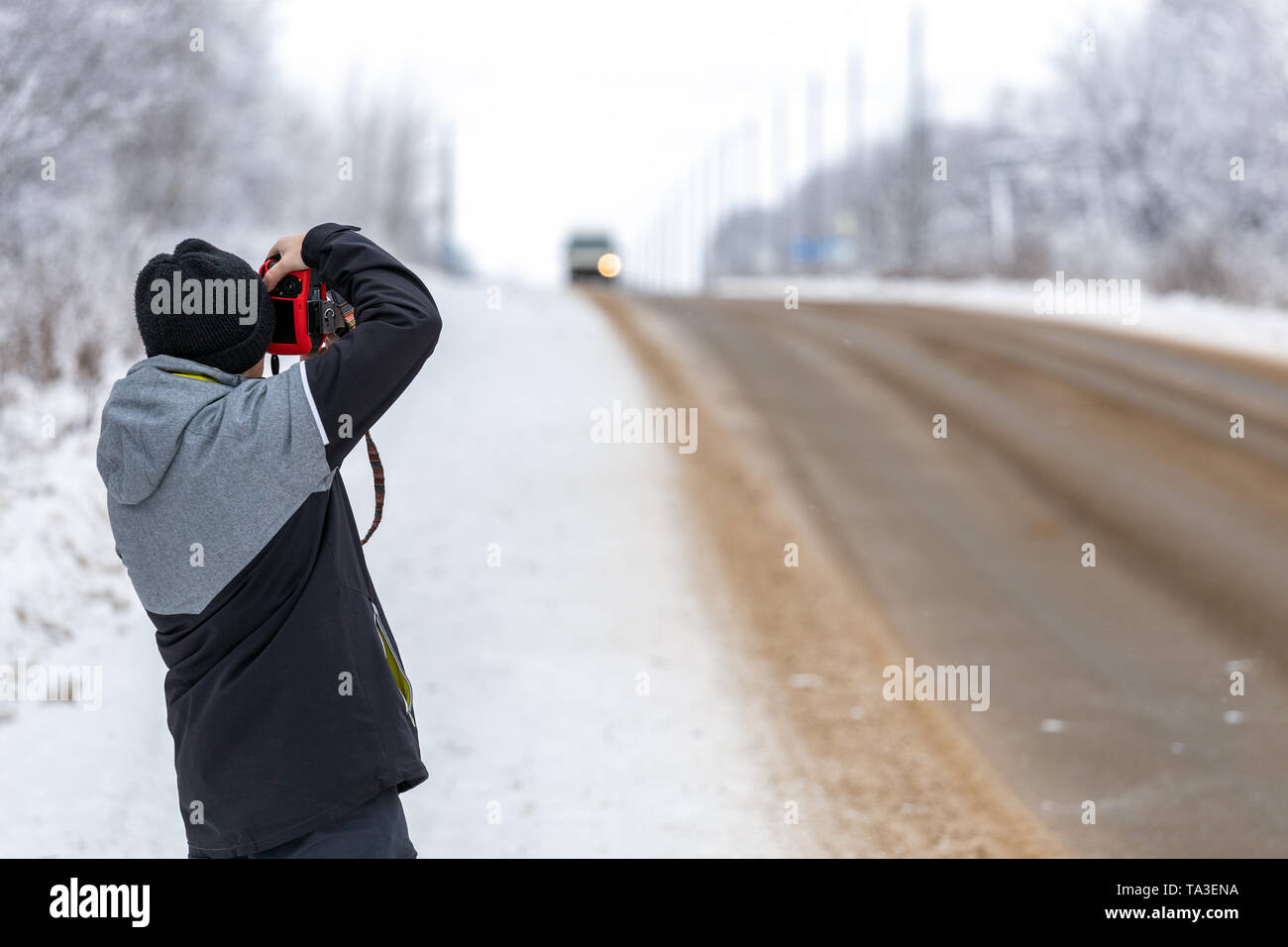 photographe photographie sur la route à la lumière du jour hivernale avec mise au point sélective Banque D'Images