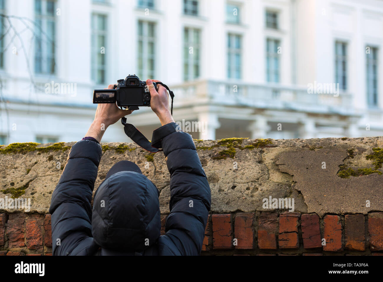 Homme en noir avec prise d'auvent au-dessus de l'écran de conférence de clôture d'un reflex numérique Banque D'Images