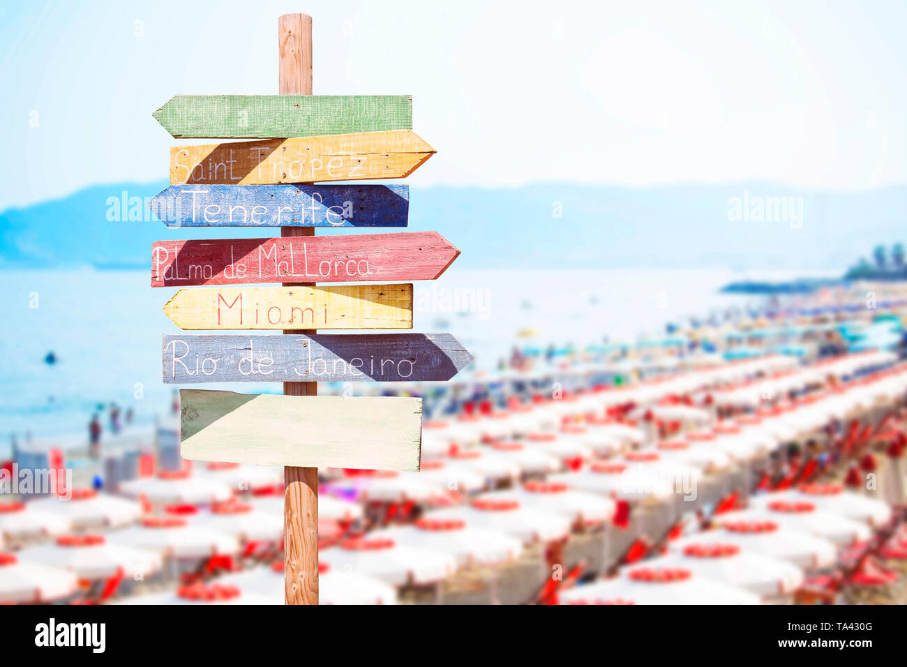 Flèche en bois signe en face de la plage unbrellas Banque D'Images