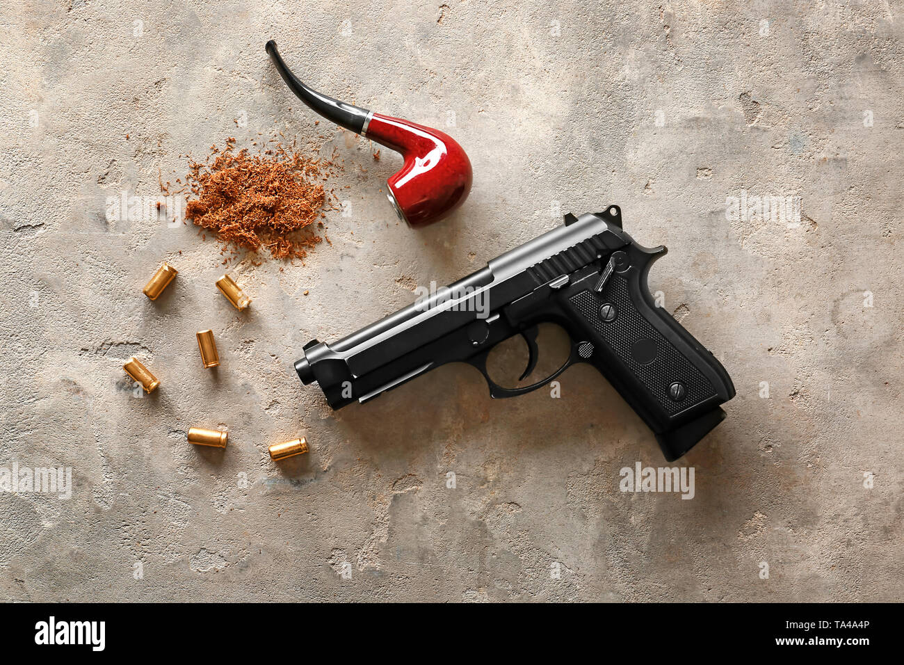 Pistolet, balles et pipe sur fond gris Banque D'Images