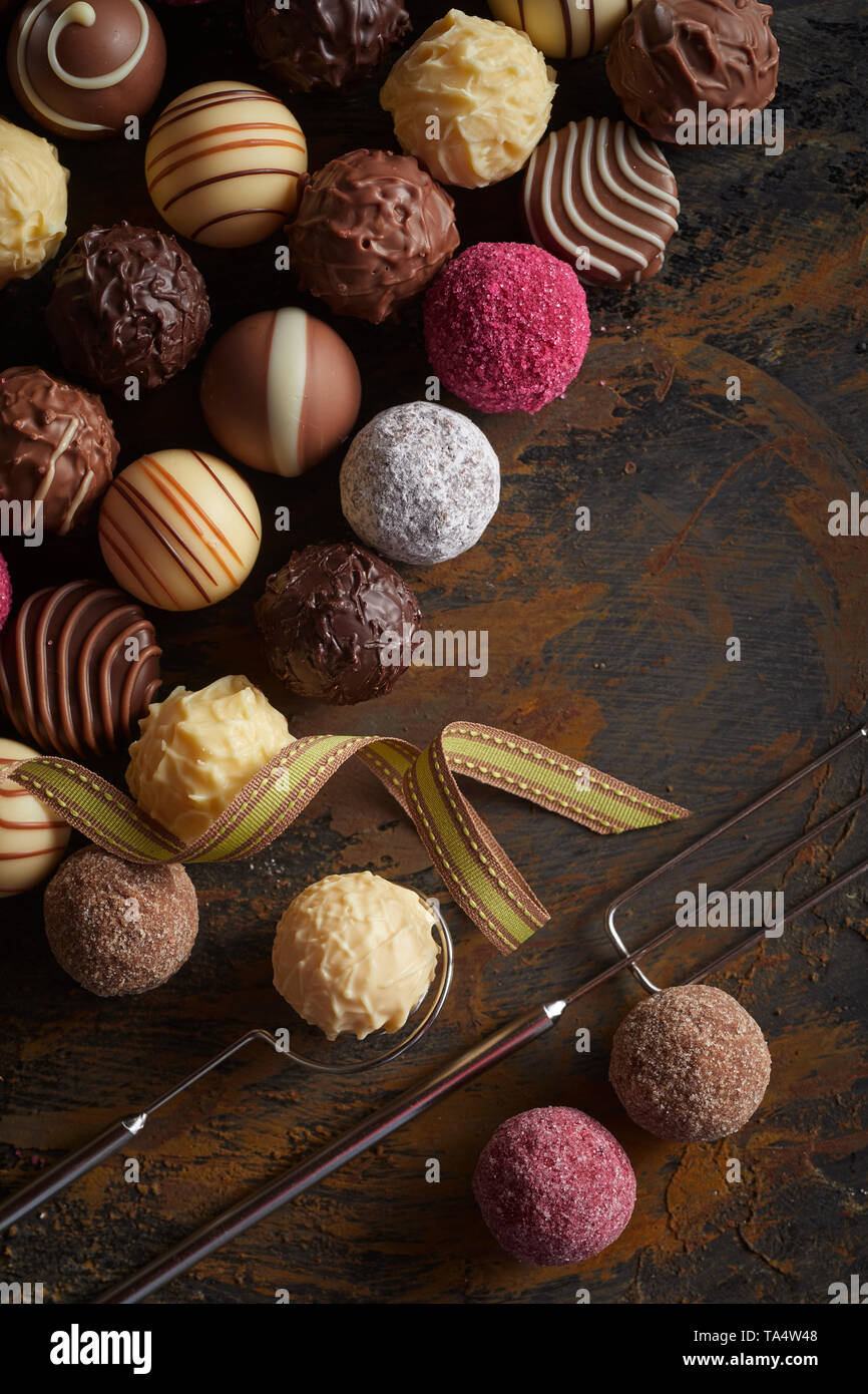 Sélection de boules de chocolat Pralines ou en rangées sur vintage rustique en bois avec fourche de l'élévateur et fils Banque D'Images