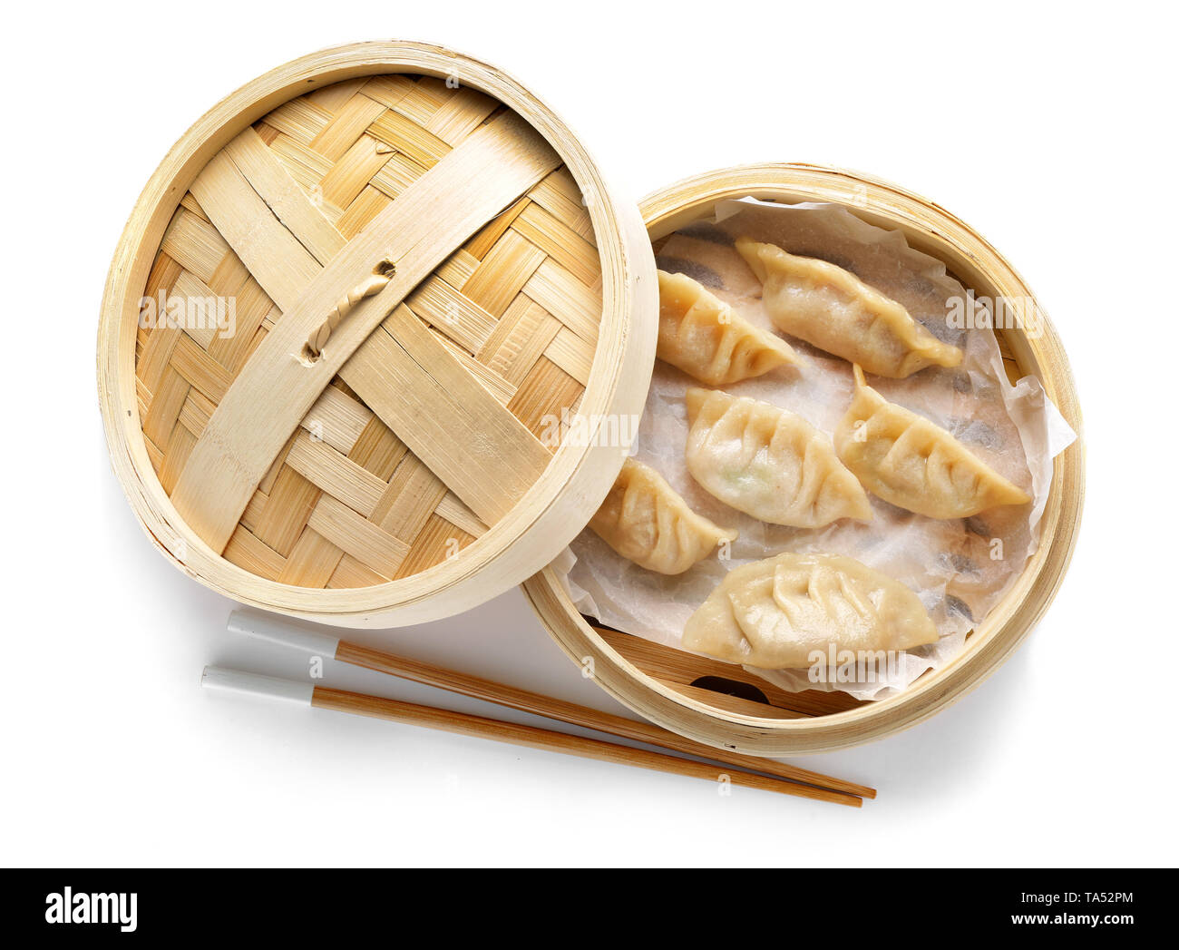 Bateau à vapeur de bambou avec de savoureux gyoza japonais sur fond blanc Banque D'Images