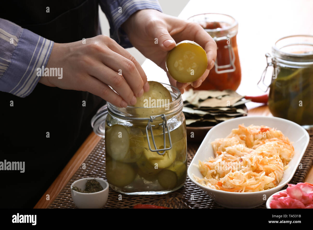 Femme avec de savoureux légumes fermentés dans la cuisine Banque D'Images