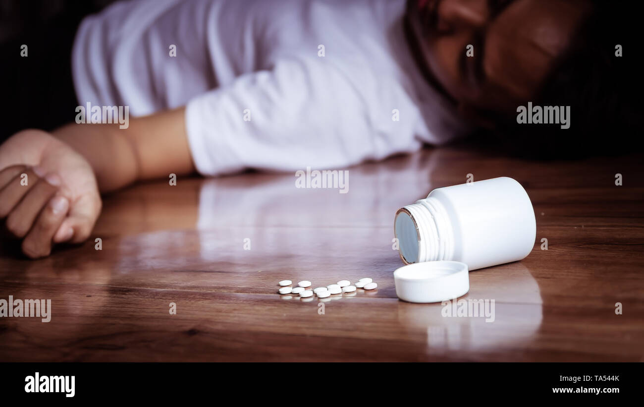 La dépression homme se suicide par une surdose de médicament. close up d'un surdosage de pilules contenant de la médecine plastique avec appuyer sur l'homme sur la cheminée Banque D'Images